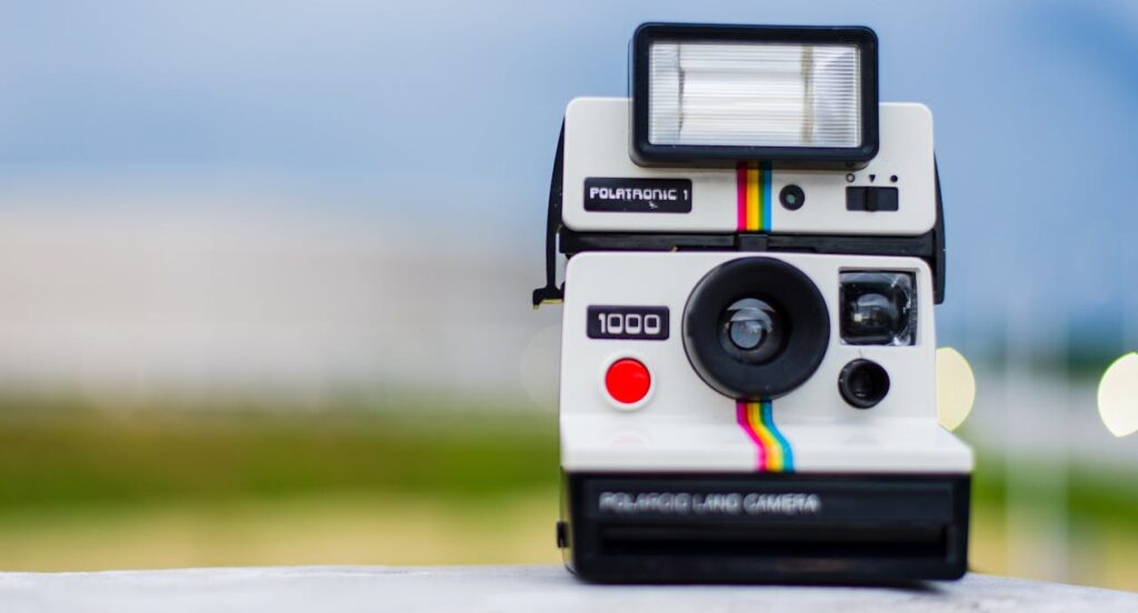 una foto de una cámara polaroid apoyada en una piedra