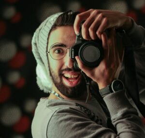 fotógrafo haciendo una foto al espectador, se le ve muy feliz