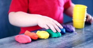 un niño jugando con plastilina de diferentes colores