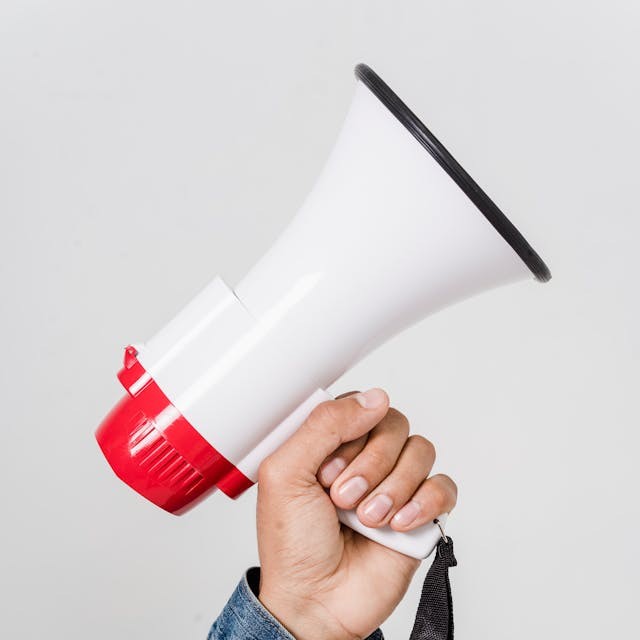 una mano sosteniendo un megáfono